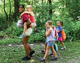 CWPD youth volunteer with four children at camp
