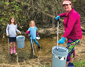 woman and two girls cleaning up litter at Greene Line Park