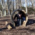 boy playing in hollow log