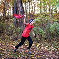 boy running in woods with bandana flag