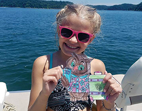 girl holding Traveling Owelexander on a boat