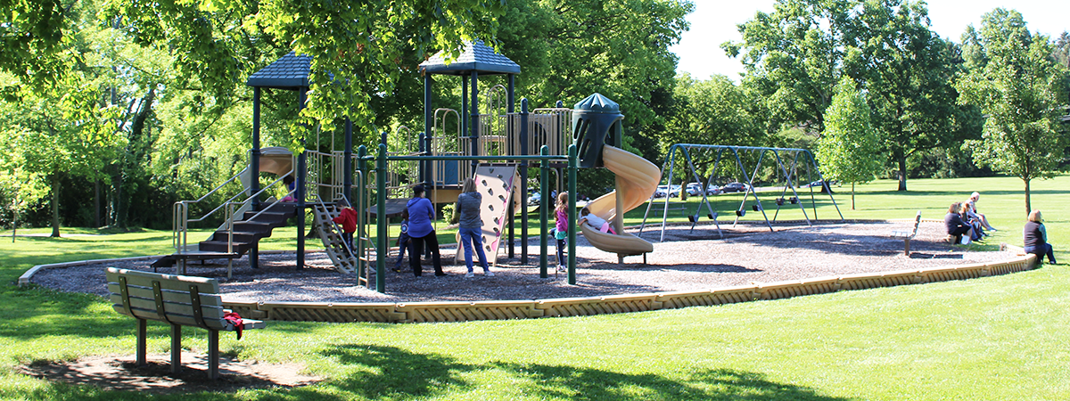 Families playing on Pleasant Hill Park playground equipment