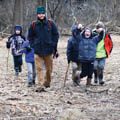 camp counselor with group of campers walking in woods
