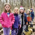 five children standing on a log
