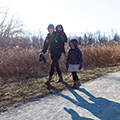 mom and daughters walking along trail in winter coats