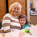 a grandmother and granddaughter at a tea party
