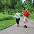 man and woman walking paved path at Oak Creek South Park