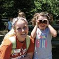 child looking through homemade binoculars with camp counselor