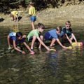 four children sending boats down Holes Creek in Grant Park