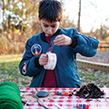 boy unrolling tape to use in his design challenge