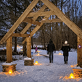 people walking a candlelit snowy path at Forest Field Park