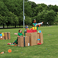 three boys with nerf guns hiding behind boxes