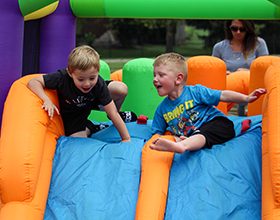 two boys race down an inflatable slide