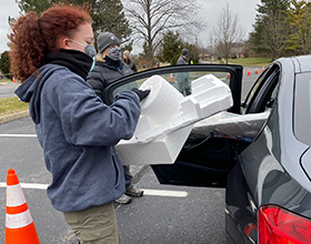 volunteer unloading Styrofoam from a car