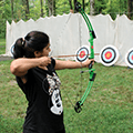 woman aiming a bow and arrow at a target