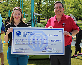 Kristen Marks and Gary Hansen hold a large check for $20,000