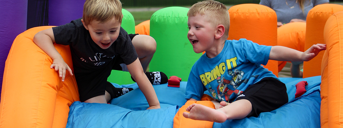 two boys race down an inflatable slide