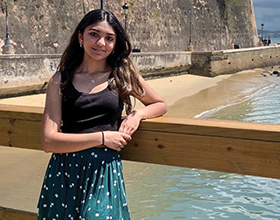 teenarger leaning on a rail with ocean in the background