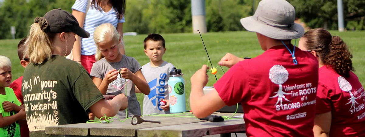 people sitting at picnic table with fishing poles