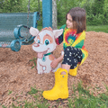 girl in rainboots sitting next to a dog cut out sign