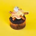 a chocolate cupcake with pretzels and icing designed to look like a campfire.