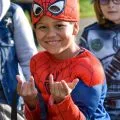 boy dressed as spiderman holding up his hands like spiderman