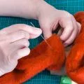 two hands needle felting orange felt