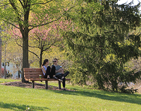 two people sitting on a park bench